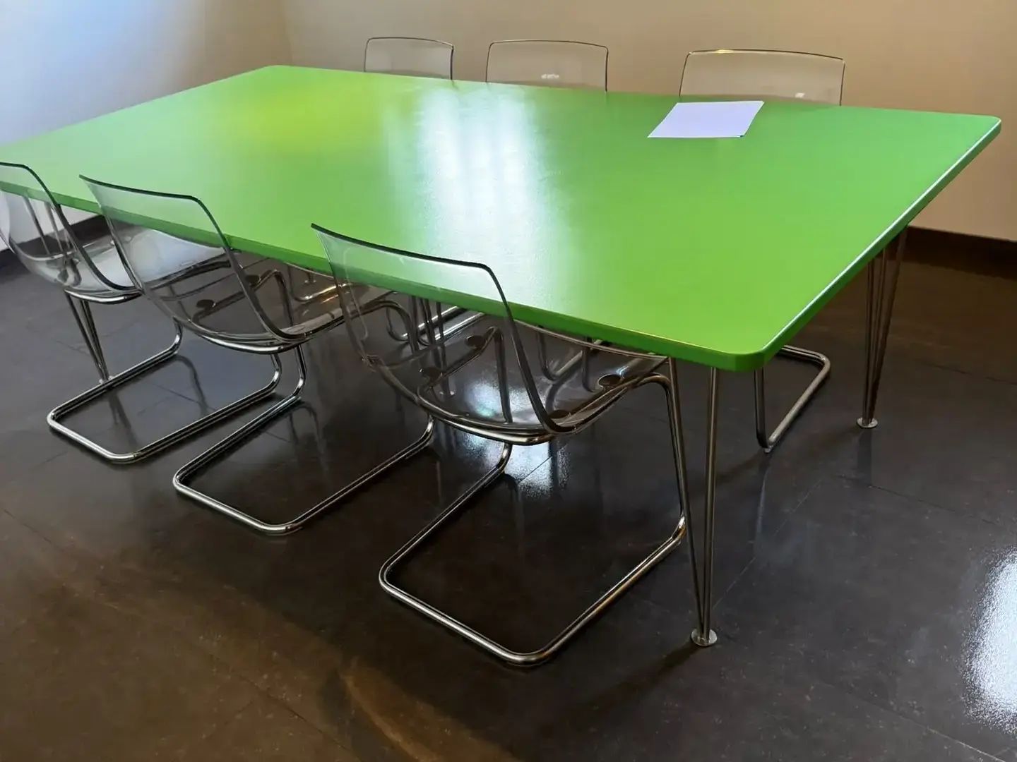 Salle de réunion après entretien : table dégagée et sol carrelé lustré.